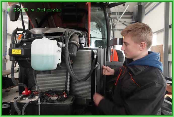 Uczeń klasy 2 technikum Maksim Paweł w czasie obsługi ciągnika rolniczego Kubota, dokonuje czyszczenia chłodnicy.