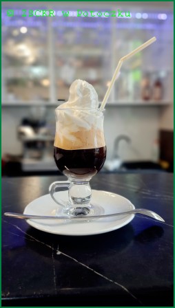 Zdjęcie przedstawia Irish coffee – kawę po irlandzku. Jest połączeniem świeżo palonej arabiki z Ameryki Południowej z delikatnym aromatem. Sporządza się ją z kawy, irlandzkiej whiskey, bitej śmietany i brązowego cukru. 