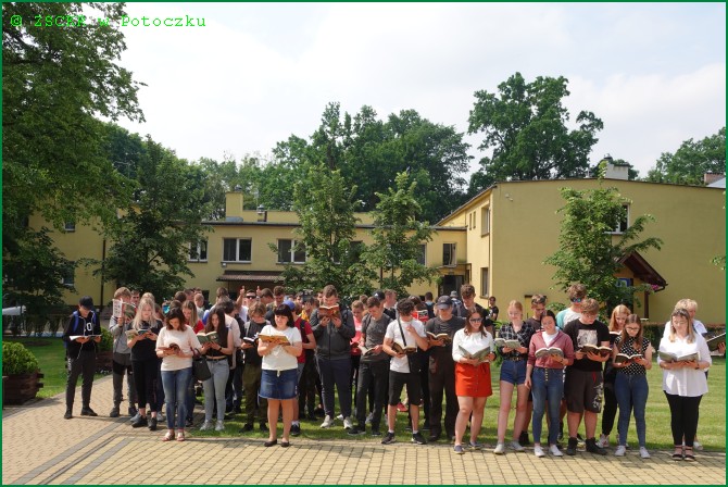 Uczniowie w akcji czytelniczej „jak nie czytam, jak czytam na tle budynku internatu ZSCKR w Potoczku- 08.06.2022 r.