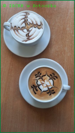 Zdjęcie przedstawia latte art ozdobione sosem czekoladowym. Poprzez użycie sosów, patyczków lub szablonów można tworzyć niepowtarzalne wzory na powierzchni kawy, np.: serca, łabędzie, tulipany, rozety.  