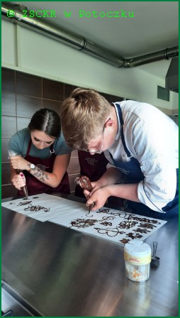 3.	Przygotowywanie dekoracji z czekolady   Zdjęcie przedstawia uczniów przygotowujących dekoracje z czekolady, która wcześniej została poddana procesowi temperowania. Powstałe wzory użyto do dekorowania tortów i tartaletek.