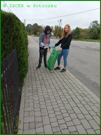 Uczniowie klasy II PTL Natalia Wicik i Jakub Dolecki sprzątają okolice przystanku przy szkole.